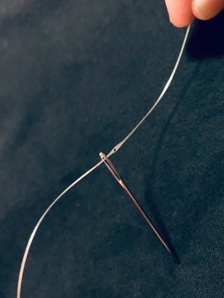 A close-up photograph shows the fiber threading through a needle