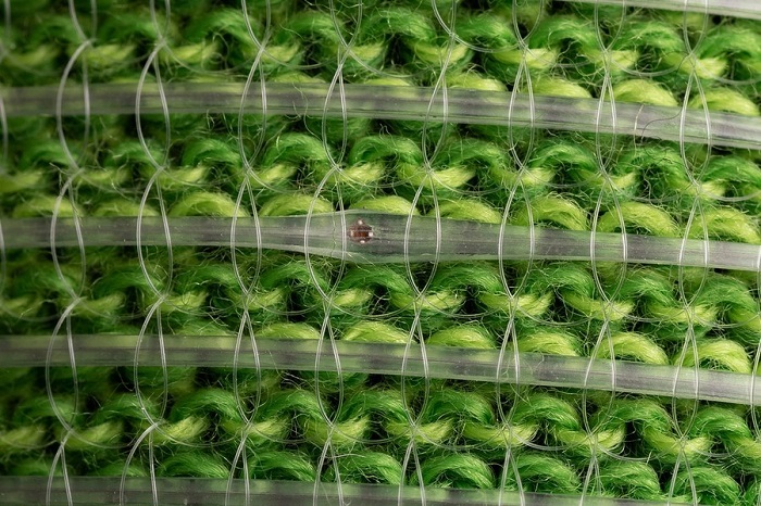 A close-up photograph of the digital fibers on green fabric