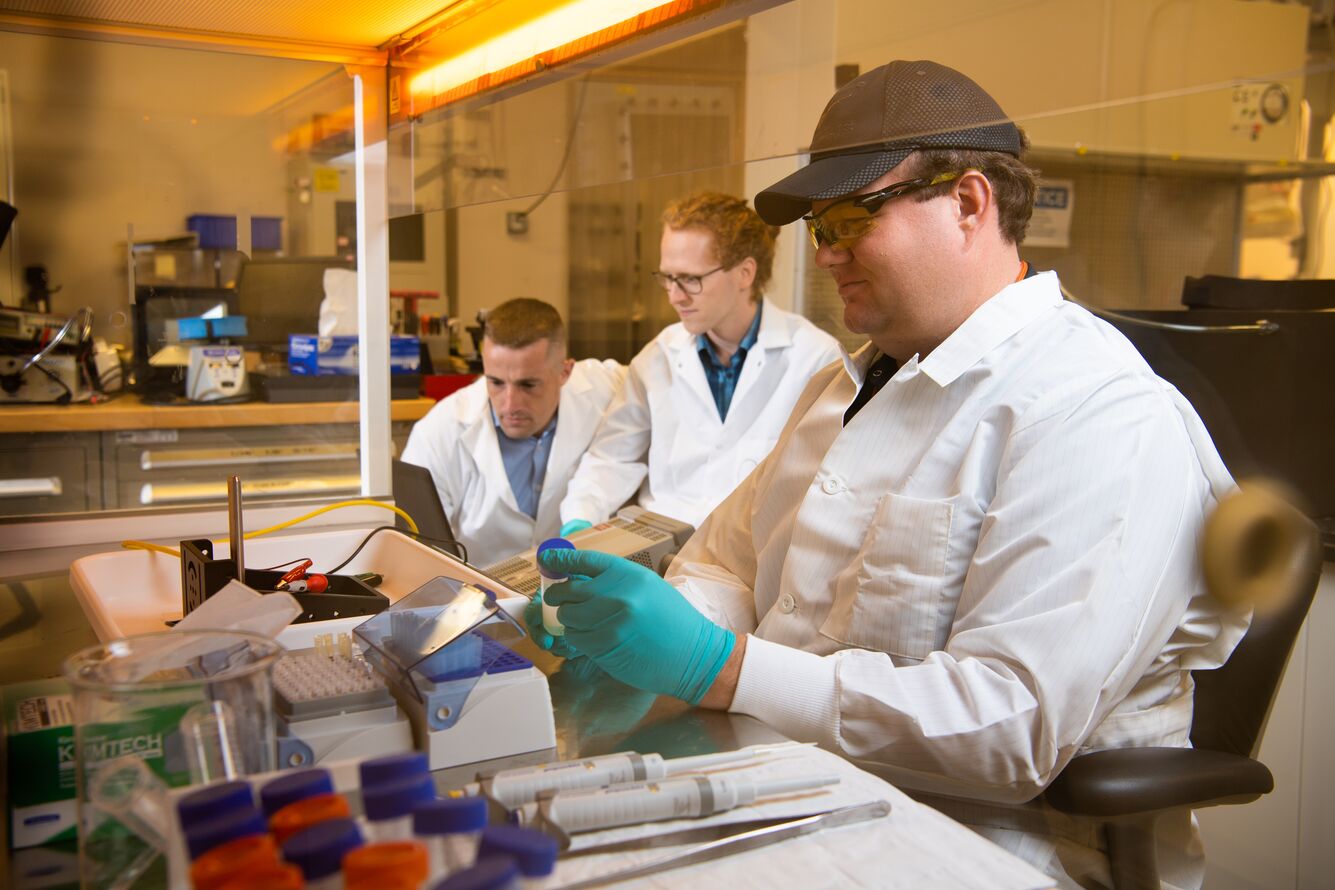 Lance Hubbard tests PNNL’s coronavirus detection system while Samuel Morrison (l) and Caleb Allen (c) look on.